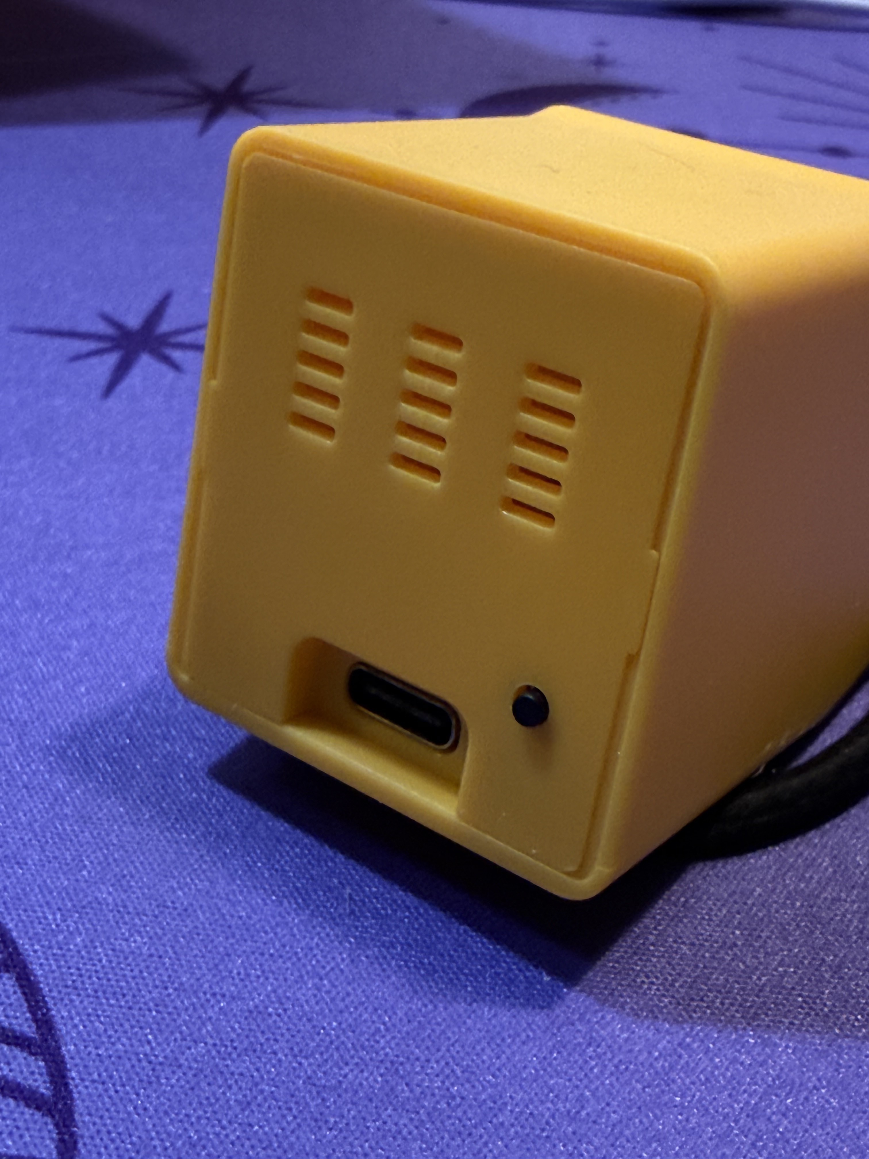 The back of the device showing ventilation slits, a button, and a USB-C port for power