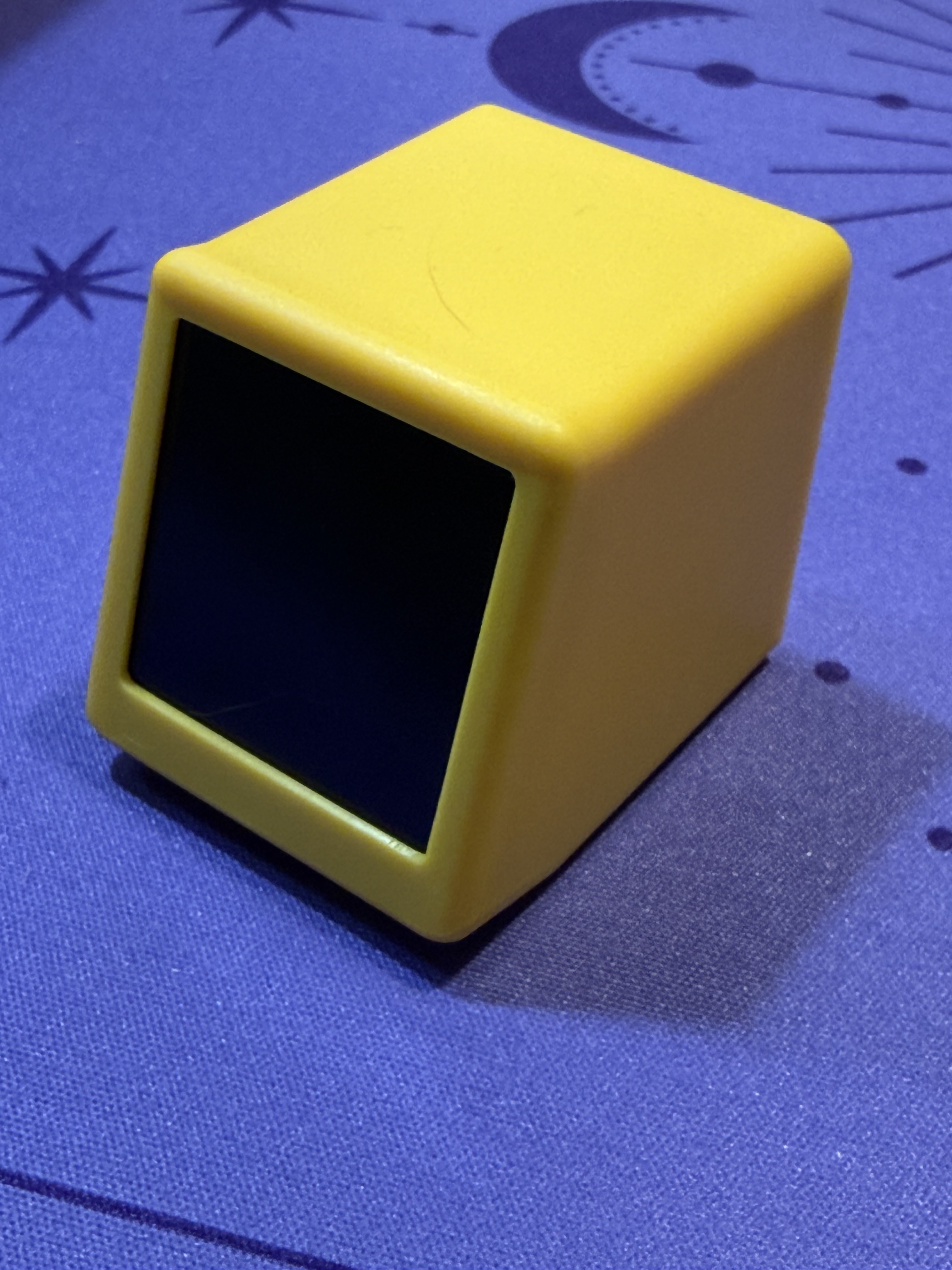 The display from the front, a cute yellow cube with a small dark screen recessed into the top face