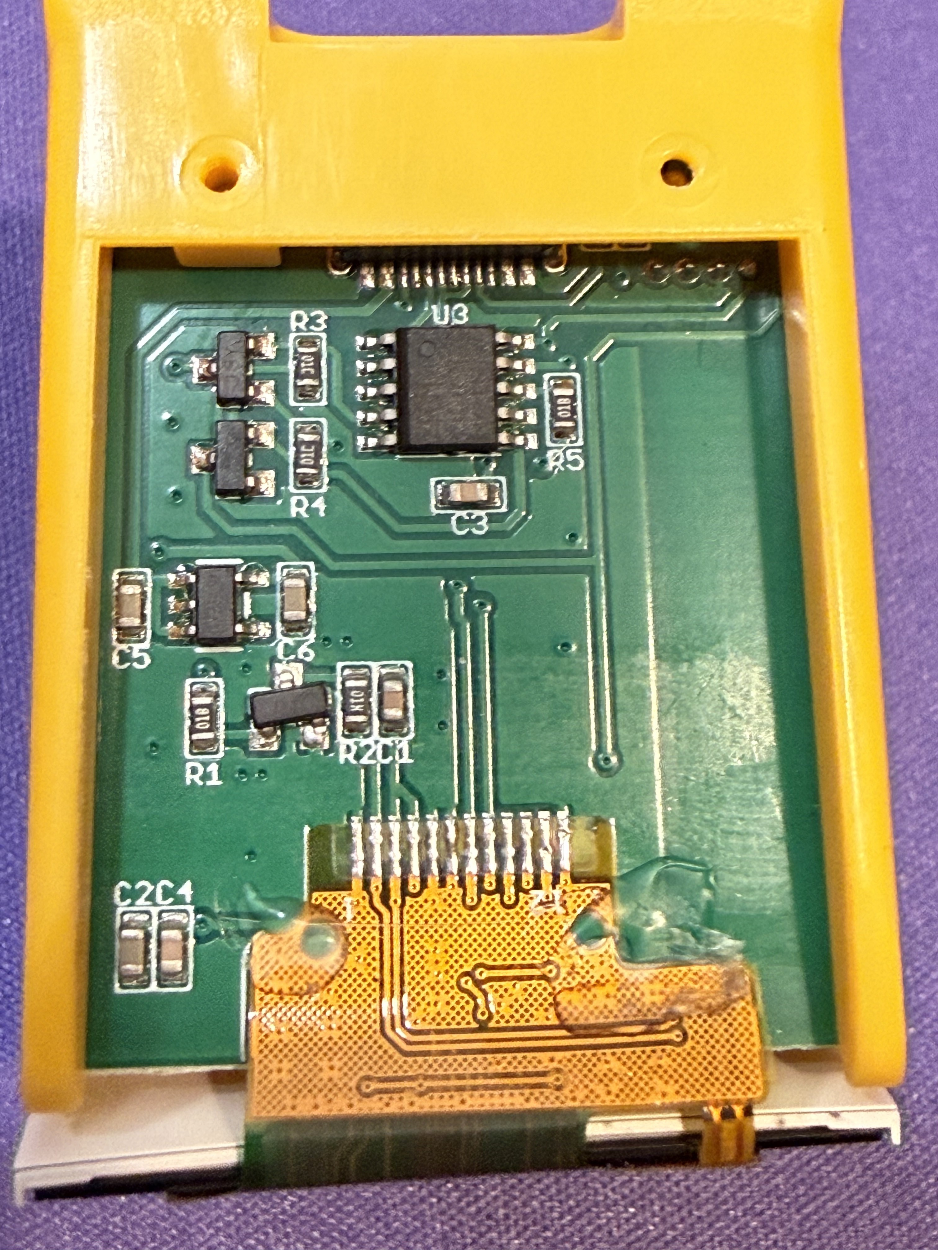 The other side of the PCB showing the display flex cable connector and several surface-mount ICs